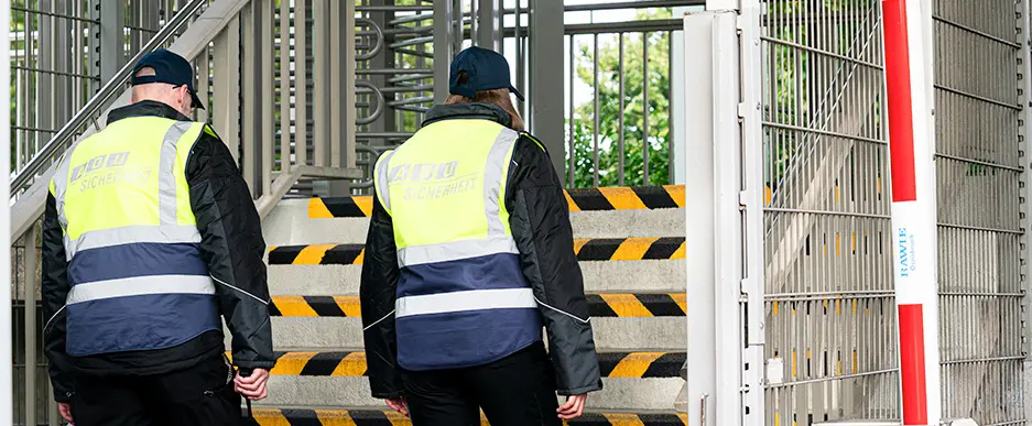Zwei Sicherheitsdienstmitarbeiter laufen einen Treppe hoch um einen besseren Überblick über die aktuelle SItuation zu haben
